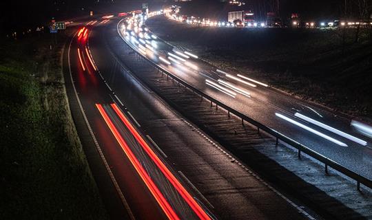 a motorway with cars whose lights are blurred