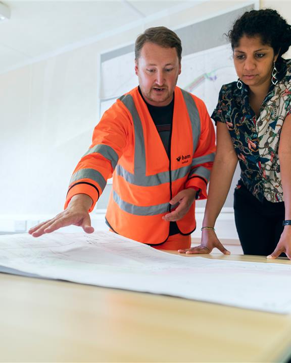 Two people studying plans