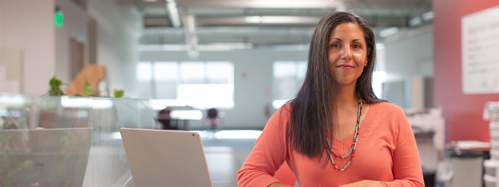 a lady in an office with a laptop