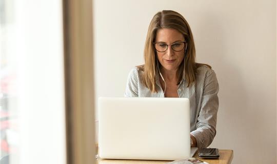 a woman sat looking at a laptop