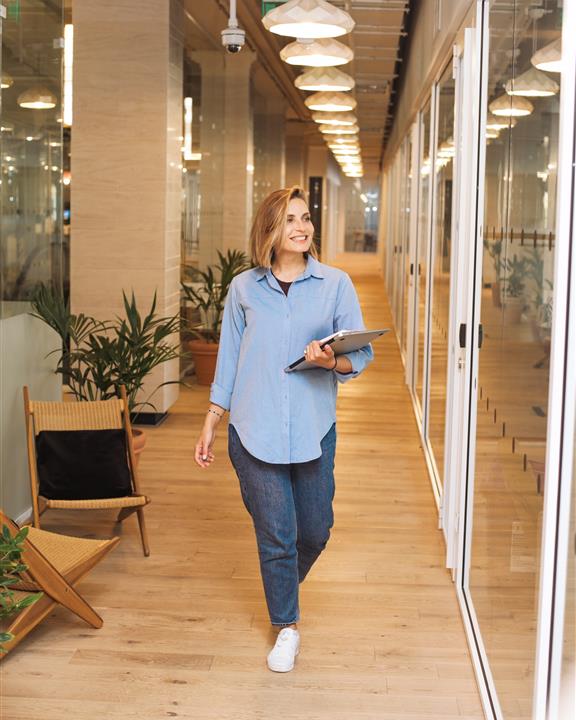 A lady walking down a corridor in a business