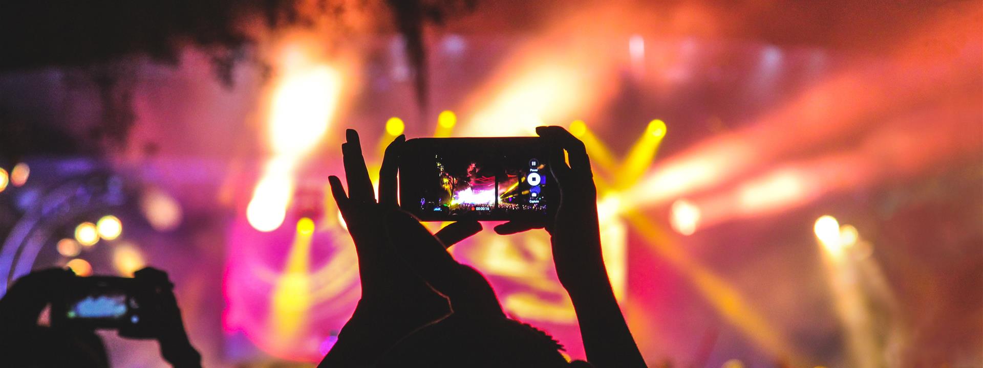 someone holding up their mobile phone at a concert