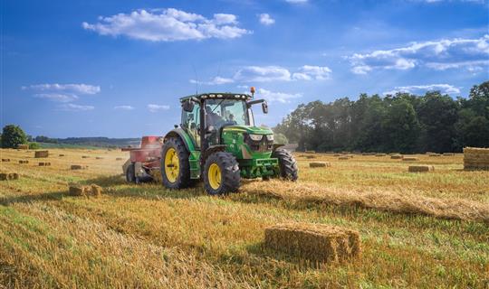 a tractor working to bail hay